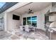 Covered patio with outdoor kitchen, dining area, and built-in grill at 6358 Rivo Lakes Blvd, Sarasota, FL 34241