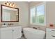 Elegant bathroom with a freestanding tub and modern vanity at 6358 Rivo Lakes Blvd, Sarasota, FL 34241