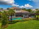 Luxury home with pool, lush landscaping, and lakefront access at 6358 Rivo Lakes Blvd, Sarasota, FL 34241