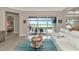Open living room with white sectional sofa, pool view, and modern decor at 6358 Rivo Lakes Blvd, Sarasota, FL 34241