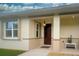 Inviting home entrance features a charming pineapple light fixture, neutral paint, and covered entry at 8930 Tuscany Isles Dr, Punta Gorda, FL 33950