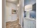 Hallway featuring wood floors, blue accent wall, decorative lamp, and artwork at 8930 Tuscany Isles Dr, Punta Gorda, FL 33950