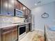 Modern kitchen featuring stainless steel appliances, dark wood cabinets, and tile backsplash at 8930 Tuscany Isles Dr, Punta Gorda, FL 33950