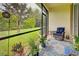Cozy screened lanai featuring comfortable chair and views of the manicured backyard and landscaping at 8930 Tuscany Isles Dr, Punta Gorda, FL 33950