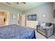 This main bedroom features a paisley bedspread, a TV, and an upholstered chair at 8930 Tuscany Isles Dr, Punta Gorda, FL 33950