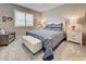 Comfortable bedroom featuring a blue patterned bedspread, plush carpet, and shuttered window at 8930 Tuscany Isles Dr, Punta Gorda, FL 33950