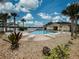 This community pool area features lounge chairs, tropical landscaping and a cabana at 8930 Tuscany Isles Dr, Punta Gorda, FL 33950