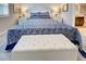 Serene bedroom with a king-size bed, a white ottoman, and soft gray carpeting at 8930 Tuscany Isles Dr, Punta Gorda, FL 33950