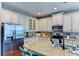 Open concept kitchen with granite countertops, stainless steel appliances, and white cabinets at 4247 Adelaar Dr, Sarasota, FL 34240