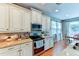 Kitchen boasts granite countertops, stainless steel appliances, and white cabinets at 4247 Adelaar Dr, Sarasota, FL 34240