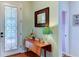 Entryway with a drop-leaf table, mirror, and lamp, showcasing hardwood floors at 4247 Adelaar Dr, Sarasota, FL 34240