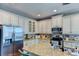 Open kitchen with granite countertops, stainless steel appliances and white cabinets at 4247 Adelaar Dr, Sarasota, FL 34240