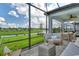 Covered patio with wicker furniture and a view of the lake at 10434 Spring Tide Way, Parrish, FL 34219