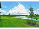Landscaped backyard with lush grass and a scenic lake view at 10434 Spring Tide Way, Parrish, FL 34219