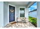 Front porch with two chairs, side table, and welcoming door decor at 10434 Spring Tide Way, Parrish, FL 34219