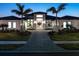 Luxury home with modern design, a paved driveway, and lush landscaping at 1158 Blue Shell Loop, Sarasota, FL 34240