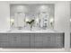 Double vanity bathroom with gray cabinets and marble tile at 11414 Brightly Dr, Venice, FL 34293