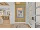 Bright entryway with wood-look tile, modern light fixture, and view into the kitchen at 11414 Brightly Dr, Venice, FL 34293