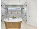 Luxurious bathroom with a soaking tub, walk-in shower, and marble tile at 11414 Brightly Dr, Venice, FL 34293