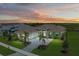 Luxury home at dusk, with stone accents and palm trees at 11414 Brightly Dr, Venice, FL 34293