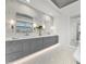 Double vanity bathroom with gray cabinets and marble tile at 11414 Brightly Dr, Venice, FL 34293