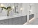 Double vanity bathroom with gray cabinets and marble tile at 11414 Brightly Dr, Venice, FL 34293