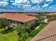 Townhome with orange tile roof, lush landscaping, and a view of the surrounding area at 13514 Messina Loop # 102, Bradenton, FL 34211