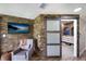 Relaxing sitting area in bedroom with stone wall and barn door to bathroom at 3500 El Conquistador Pkwy # 339, Bradenton, FL 34210