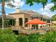 Community clubhouse with outdoor seating overlooking a pond at 4427 Longmeadow # 48, Sarasota, FL 34235