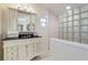 Bathroom with glass block shower and white vanity at 2701 Gulf Dr, Holmes Beach, FL 34217