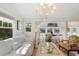Open living space with a white couch, coffee table and chandelier, view into dining area at 2701 Gulf Dr, Holmes Beach, FL 34217