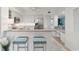 Bright kitchen featuring granite counters, stainless steel appliances, breakfast bar, and white cabinetry at 1260 Dolphin Bay Way # 203, Sarasota, FL 34242