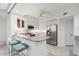 Well-lit kitchen boasts white cabinets, stainless steel refrigerator, and granite countertops with a breakfast bar at 1260 Dolphin Bay Way # 203, Sarasota, FL 34242