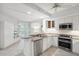 Modern kitchen with stainless steel appliances, granite counters, white cabinets, and breakfast bar at 1260 Dolphin Bay Way # 203, Sarasota, FL 34242