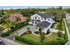 Stunning aerial view of a well-manicured two-story white home with a black roof and lush landscaping at 1783 Bayview Dr, Sarasota, FL 34239