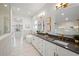 The luxurious bathroom offers double vanity with marble countertops, a soaking tub, and decorative gold fixtures at 1783 Bayview Dr, Sarasota, FL 34239