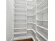 A bright white walk-in closet with generous custom shelving space and hardwood floors at 1783 Bayview Dr, Sarasota, FL 34239