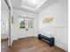 Elegant foyer with wood floors, a stylish bench, and double doors that provide plenty of natural light at 1783 Bayview Dr, Sarasota, FL 34239
