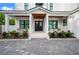 Inviting front entrance of a white home featuring double doors and a charming covered porch with seating area at 1783 Bayview Dr, Sarasota, FL 34239