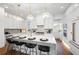 Bright kitchen features white cabinets, an island with marble counters and pendant lighting at 1783 Bayview Dr, Sarasota, FL 34239