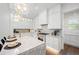 Bright kitchen features white cabinets, marble counters, stainless steel appliances and pendant lighting at 1783 Bayview Dr, Sarasota, FL 34239