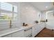 Well-lit kitchenette with white cabinets, marble counters, and stainless steel appliances at 1783 Bayview Dr, Sarasota, FL 34239