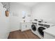 This bright laundry room features modern washer and dryer, sink, white cabinets, and wood-look flooring at 1783 Bayview Dr, Sarasota, FL 34239