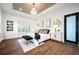 Bright main bedroom boasts hardwood floors, tray ceiling with chandelier, and ample natural light from the window at 1783 Bayview Dr, Sarasota, FL 34239