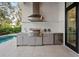 Outdoor kitchen features modern appliances, gray cabinets and ample countertop space at 1783 Bayview Dr, Sarasota, FL 34239
