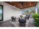 Relaxing covered patio features tile flooring, shiplap, a wooden ceiling, comfortable seating, and ample space at 1783 Bayview Dr, Sarasota, FL 34239