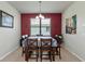 Bright dining room with rich red accent wall and seating for six at 5919 Lexington Dr, Parrish, FL 34219
