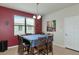 Bright dining room with a square table and six chairs, featuring a red accent wall at 5919 Lexington Dr, Parrish, FL 34219