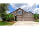 Two-story house with stone accents, a three-car garage and landscaping at 5919 Lexington Dr, Parrish, FL 34219