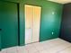 Bedroom with green and dark walls, tile floors, and a closet at 3553 Syracuse St, Port Charlotte, FL 33952